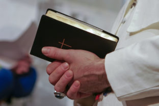 Man in popes garment holding holy bible