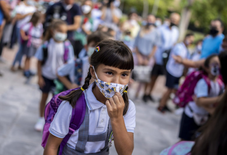 A girl wearing a face mask to protect against the spread of coronavirus arrives at Maestro Padilla school as the new school year begins, in Madrid, Spain, Tuesday, Sept. 7, 2021. Around 8 million children in Spain are set to start the new school year. (AP Photo/Manu Fernandez)