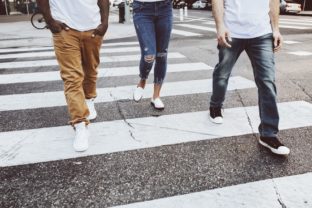 Streetwear apparel jeans men and women crossing road in city