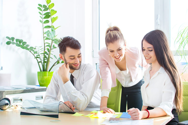 Young business team reading sticky notes on the work desk in off