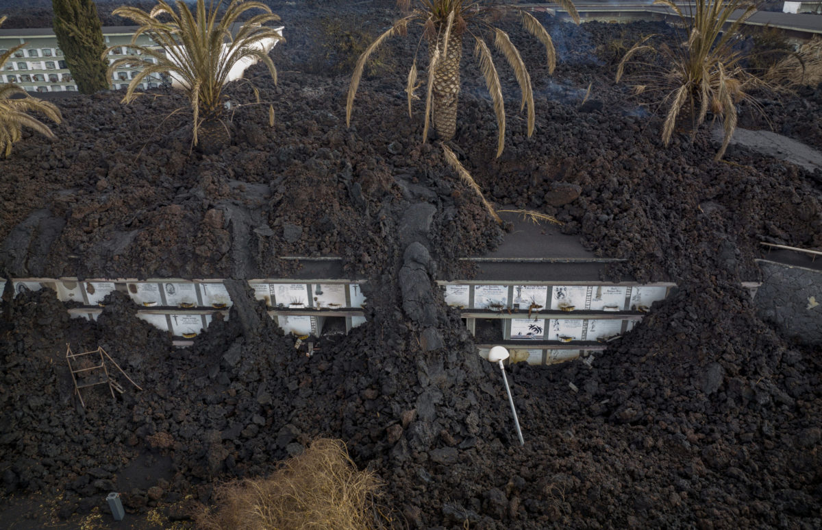 Spain VolcanoLava from the volcano flows covering the cemetery of La Manchas on the Canary island of La Palma, Spain, Wednesday, Dec.1 2021. A fresh stream of lava from volcano on Spain's La Palma threatened on Wednesday to engulf a parish church that has so far survived the eruption that shows no signs of relenting in its tenth week. A nearby cemetery has been completely covered, burying for a second time the remains of 3,000 people.