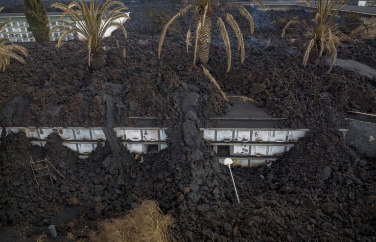 Spain VolcanoLava from the volcano flows covering the cemetery of La Manchas on the Canary island of La Palma, Spain, Wednesday, Dec.1 2021. A fresh stream of lava from volcano on Spain's La Palma threatened on Wednesday to engulf a parish church that has so far survived the eruption that shows no signs of relenting in its tenth week. A nearby cemetery has been completely covered, burying for a second time the remains of 3,000 people.