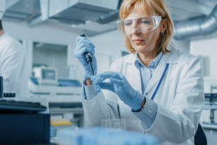 Female Research Scientist Uses Micro Pipette while Working with Test Tubes. People in Innovative Pharmaceutical Laboratory with Modern Medical Equipment for Genetics Research.