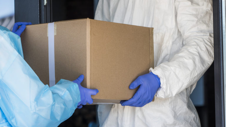 Delivery of medical equipment to the hospital. People in protective suits hand over boxes