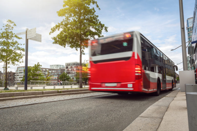 Bus passing by on a street in urban surroundings