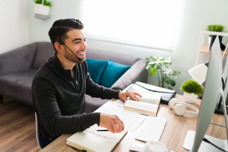 Young guy is very happy to be working remotely as a translator