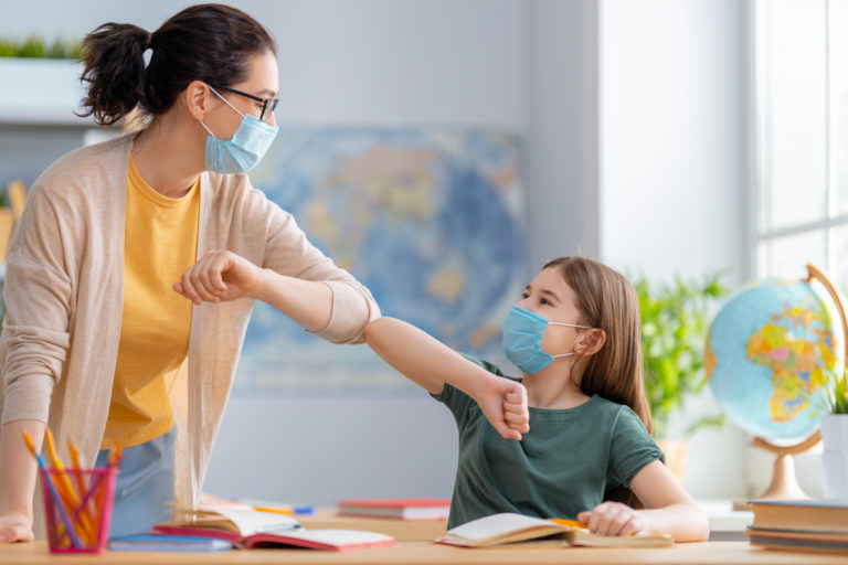 Kids are wearing facemasks learning in class