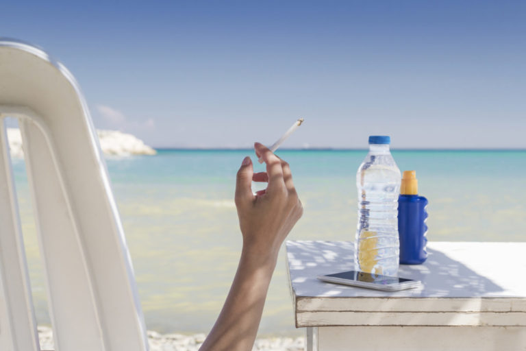 Woman smoking at the beach