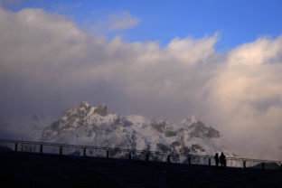 Austria Two man stand on an empty spectators tribune in front of the Alps mountains during the competition round at the ski jumping World Cup in Bischofshofen, Austria, Saturday, Jan. 8, 2022. () Ski Jumping World Cup