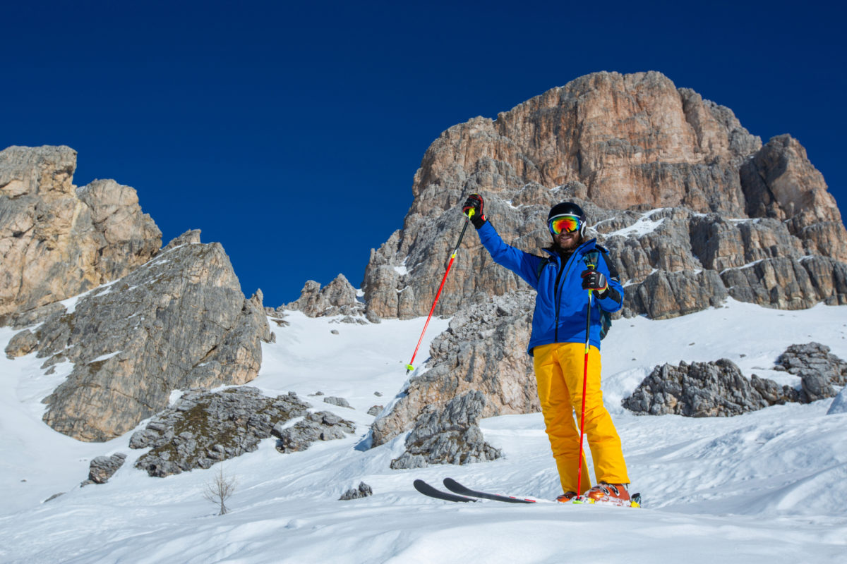 Skier stand on slope in winter mountains