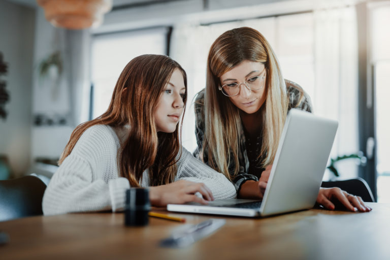 Mother and child doing homeschooling, e learning at home