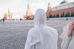 A health care worker in white overalls standing on the Red Square in Moscow