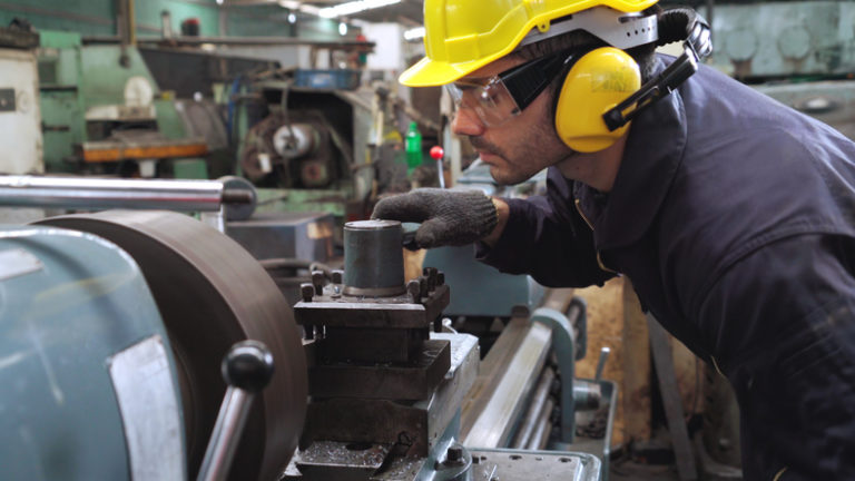 Smart factory worker using machine in factory workshop