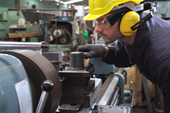 Smart factory worker using machine in factory workshop