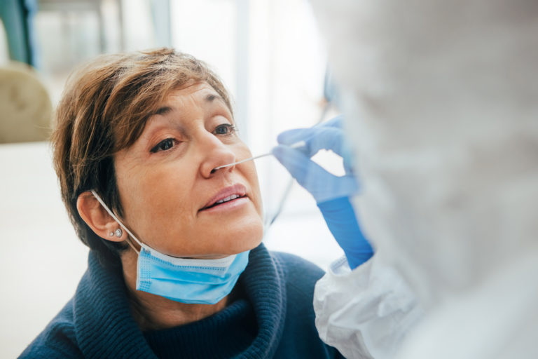 Close up of the face of a senior female patient being tested for Covid 19