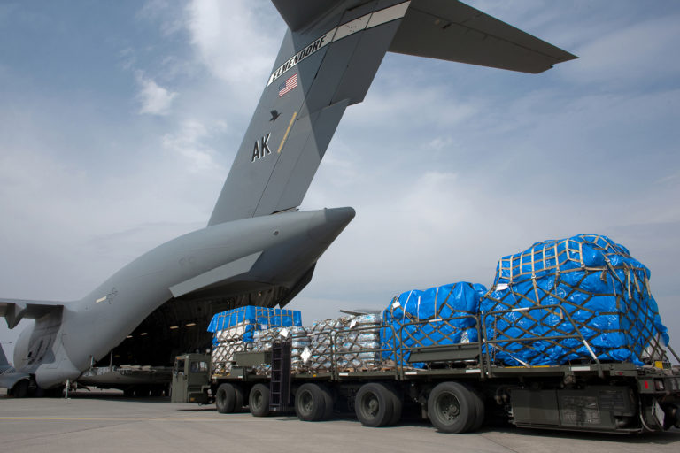 A Japanese soldier marshals vehicles from a C 17 Globemaster III.