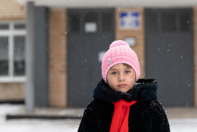 Seven year old Polina stands in front her school. She loves to sing and dreams of becoming an artist. Polina has no recollection of the shell that exploded in the courtyard of her house six years ago and killed her grandmother.