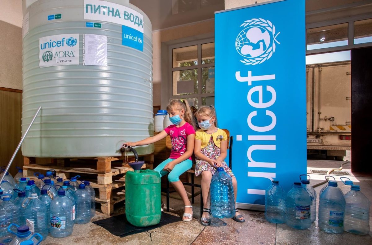 Sisters Dasha, eight, and Katia, six, collect their week’s supply of water while wearing facemasks as a precaution against COVID 19. “Not only do we have shelling here and no water, but also the coronavirus. I was so afraid in the spring, I didn’t le