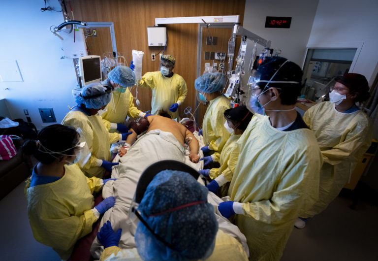Virus Outbreak Canada Respiratory therapist Mehul Delvada, back centre, and health care workers prone a ventilated COVID 19 patient who's also an unvaccinated nurse in the intensive care unit at the Humber River Hospital during the COVID 19 pandemic in Toronto