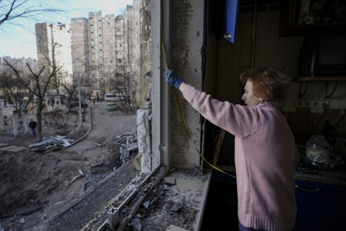 APTOPIX Russia A woman measures a window before covering it with plastic sheets in a building damaged by a bombing the previous day in Kyiv, Ukraine, Monday, March 21, 2022. As Russia intensified its effort to pound Mariupol into submission, its ground offensive in other parts of Ukraine has become bogged down. Western officials and analysts say the conflict is turning into a grinding war of attrition, with Russia bombarding cities Ukraine War