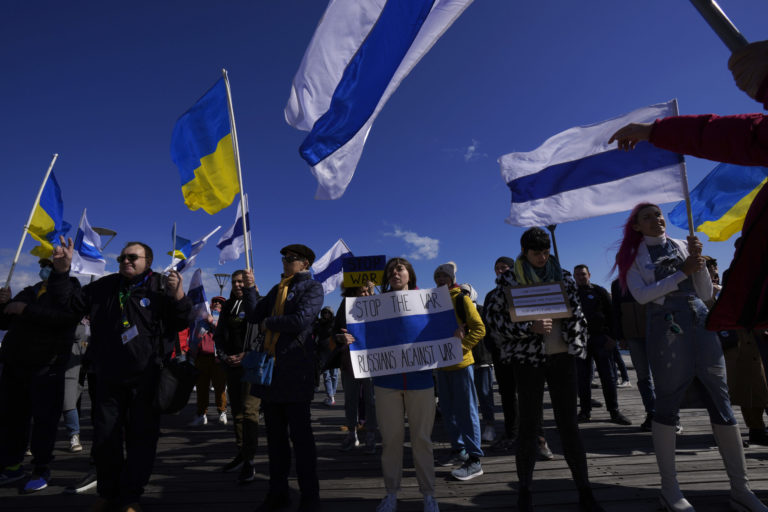 Cyprus Russia Ukraine Russian protesters living in Cyprus wave Ukrainian and Russian national flags without the red stripe, during a protest against Russia's invasion of Ukraine, in southern port city of Limassol, Cyprus, Sunday, March 13, 2022. Dozens of Russian nationals joined Ukrainians in the coastal resort town of Limassol Sunday to protest the war in Ukraine, chanting slogans like "Stop the war, stop Putin" and waving blue and white flags they said where the Russian national flag without the red stripe that represented "blood and violence." War