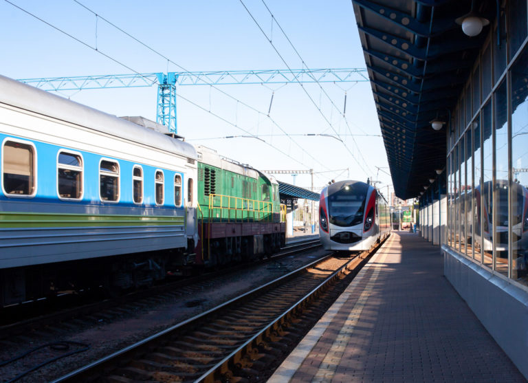Modern high speed train moves fast along the platform. Train arrive. The train arrives at the train station. Old passenger trains waiting.