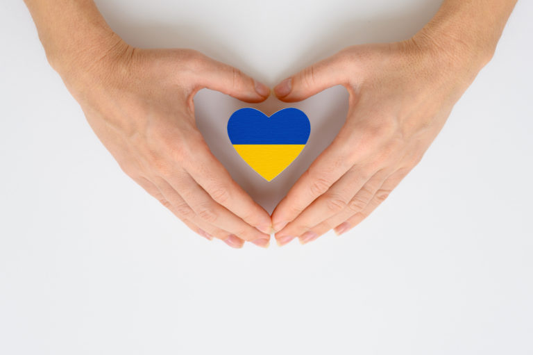 The national flag of Ukraine in female hands. The concept of patriotism, respect and solidarity with the citizens of Ukraine