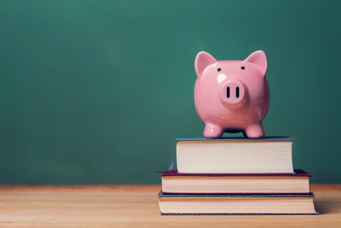 Piggy bank on top of books, cost of education theme