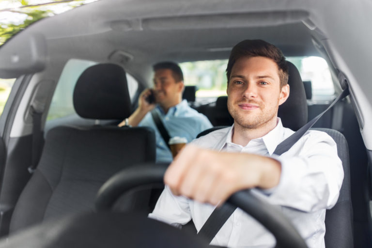 Male driver driving car with passenger