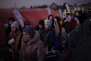 Poland Russia Ukraine War A group of people, who have fled Ukraine, stand in a line after arriving at the border crossing in Medyka, Poland, Sunday, March 13, 2022. Now in its third week, the war has forced more than 2.5 million people to flee Ukraine
