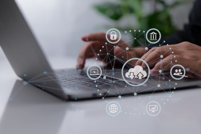 Man uses a laptop with a cloud computing schematic. Cloud comput