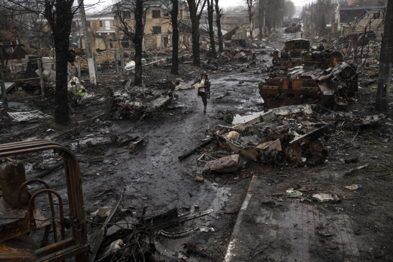 APTOPIX Russia Ukraine War A woman walks amid destroyed Russian tanks in Bucha, in the outskirts of Kyiv, Ukraine