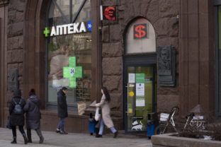 Russia Drug Shortages People walk past a pharmacy and a currency exchange on a main street in Moscow, Russia, Friday, April 1, 2022. ()