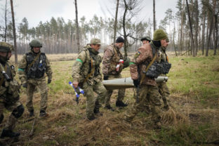 Ukrainian soldiers carry a fragment of a Russian 'Uragan' missile after recent fights in the village of Berezivka, Ukraine