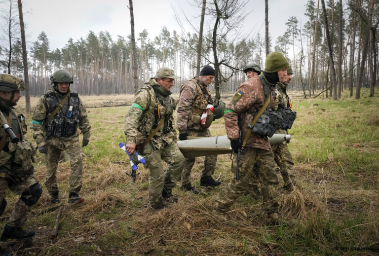 Ukrainian soldiers carry a fragment of a Russian 'Uragan' missile after recent fights in the village of Berezivka, Ukraine