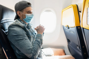 Man wearing prevention mask during a flight inside an airplane