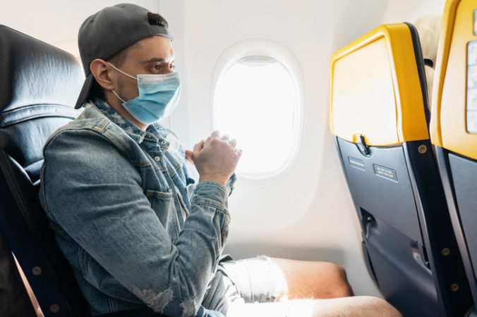 Man wearing prevention mask during a flight inside an airplane