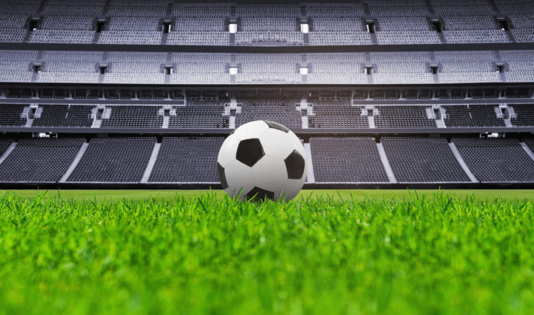 Soccer ball in the stadium in front of empty grandstands
