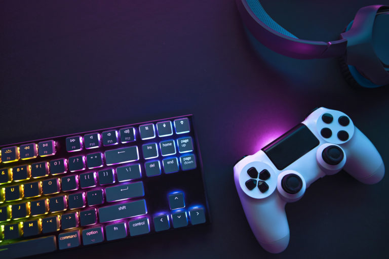 Top down view of colorful illuminated gaming accessories laying on table.