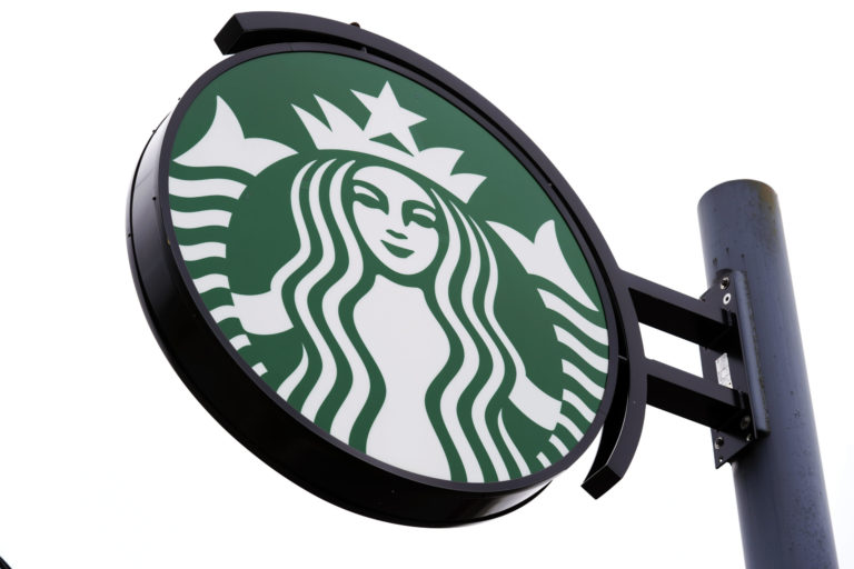 FILE - A sign at a Starbucks location in Havertown, Pa., is seen April 26, 2022. Starbucks says it will now offer employees enrolled in its health care plan reimbursement for eligible travel expenses when accessing abortion or gender-affirming procedures, when those services are not available within 100 miles of a worker’s home. The Seattle coffee chain said Monday, May 16, 2022 that the benefit will also be available to dependents of employees enrolled in its health care coverage. ()