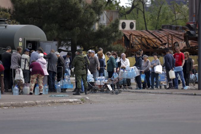 Local civilians gather to receive pure water distributed by Russian Emergency Situations Ministry in Mariupol, in territory under the government of the Donetsk People's Republic, eastern Ukraine, Friday, May 27, 2022. ()