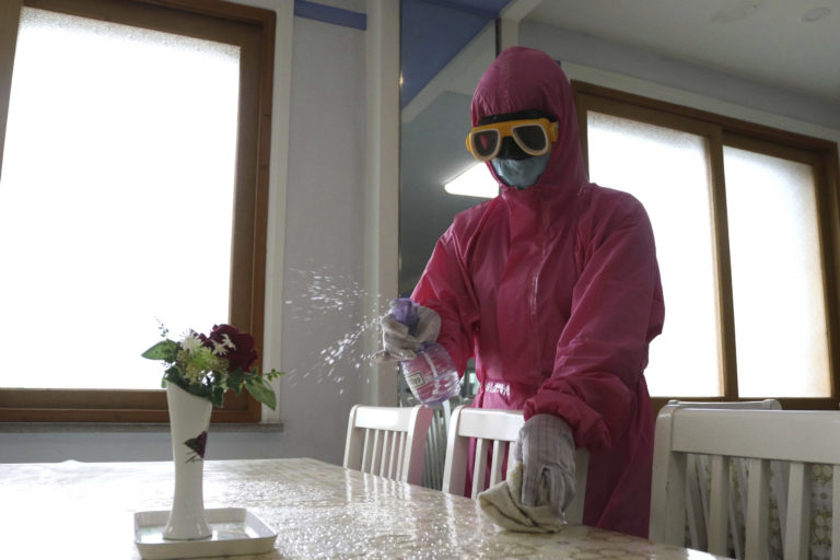 FILE - An employee of Pyongyang Dental Hygiene Products Factory disinfects the floor of a dinning room as the state increased measures to stop the spread of illness in Pyongyang, North Korea on May 16, 2022. According to North Korea, its fight against COVID-19 has been impressive: About 3.3 million people have been reported sick with fevers, but only 69 have died.