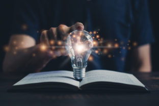 Glowing light bulb and book or text book with futuristic icon. Self learning or education knowledge and business studying concept. Idea of learning online class or e learning at home.
