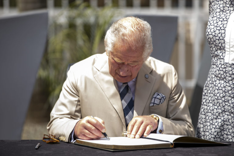 Britain's Prince Charles signs the visitors book at the Kigali Genocide Memorial in the capital Kigali, Rwanda Wednesday, June 22, 2022. Prince Charles has become the first British royal to visit Rwanda, representing Queen Elizabeth II as the ceremonial head of the Commonwealth at a summit where both the 54-nation bloc and the monarchy face uncertainty