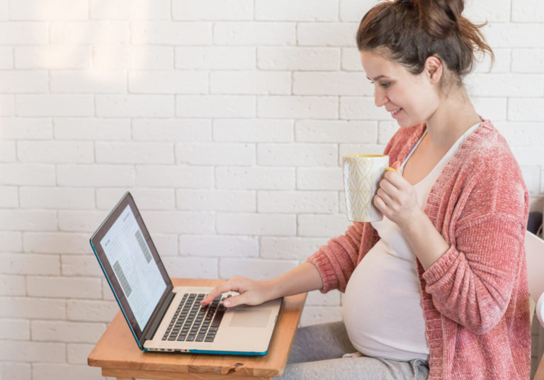Pregnant woman working on the laptop at home