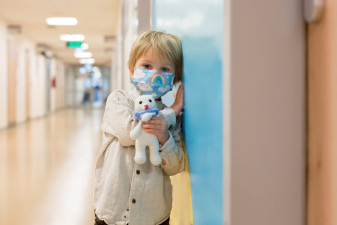 Child, boy, sitting in the waiting room in emergency, waiting for examination