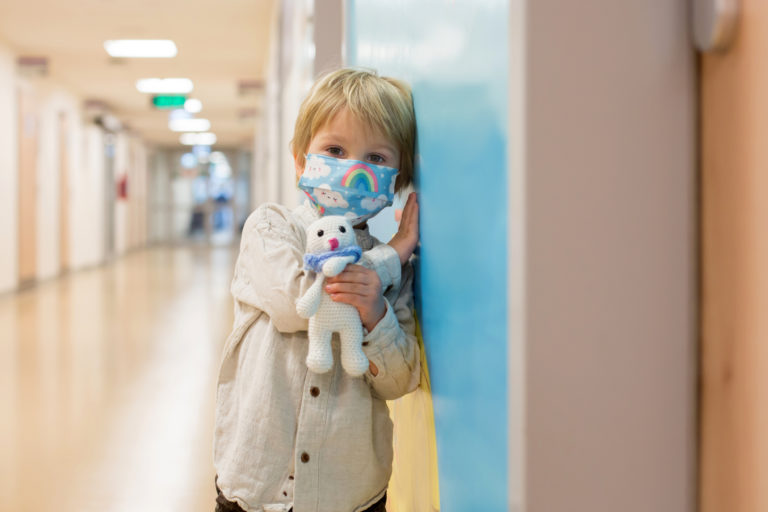 Child, boy, sitting in the waiting room in emergency, waiting for examination