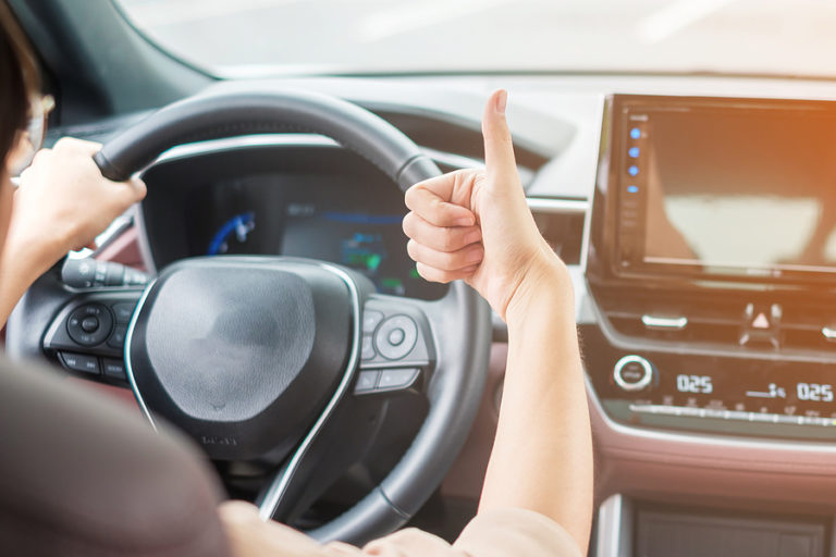 Woman Hand Thumb Up During Driving A Car On The Road, Hand Contr