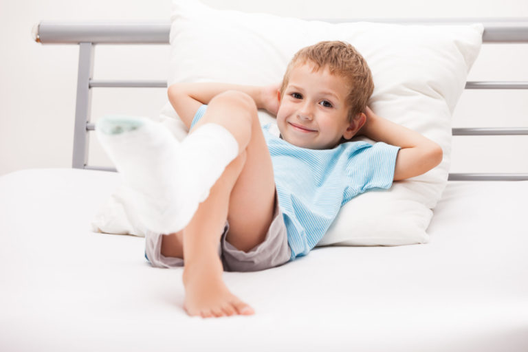 Little child boy with plaster bandage on leg heel fracture or br