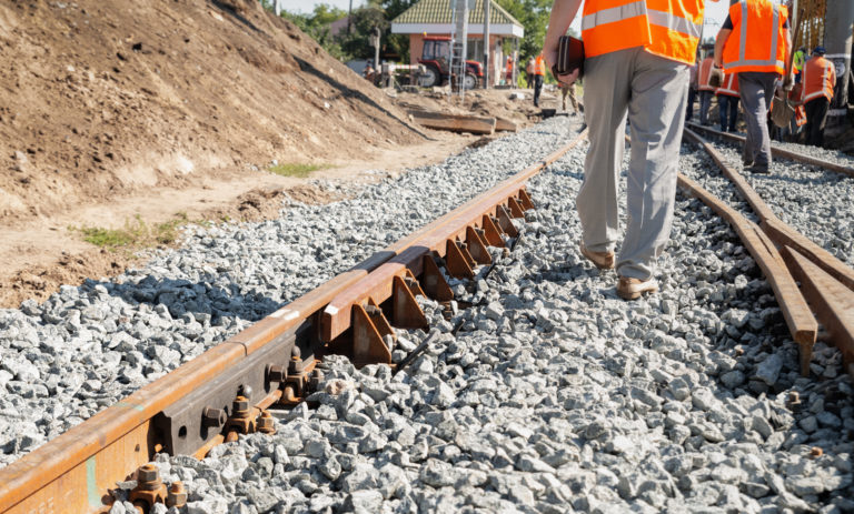 Railway repair. Uniformed workers are changing the old railway line.